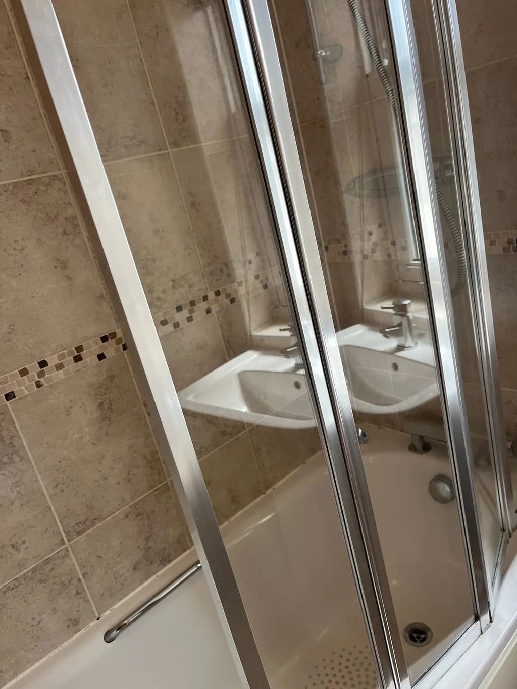 Bath shower doors clear over mosaic tiles