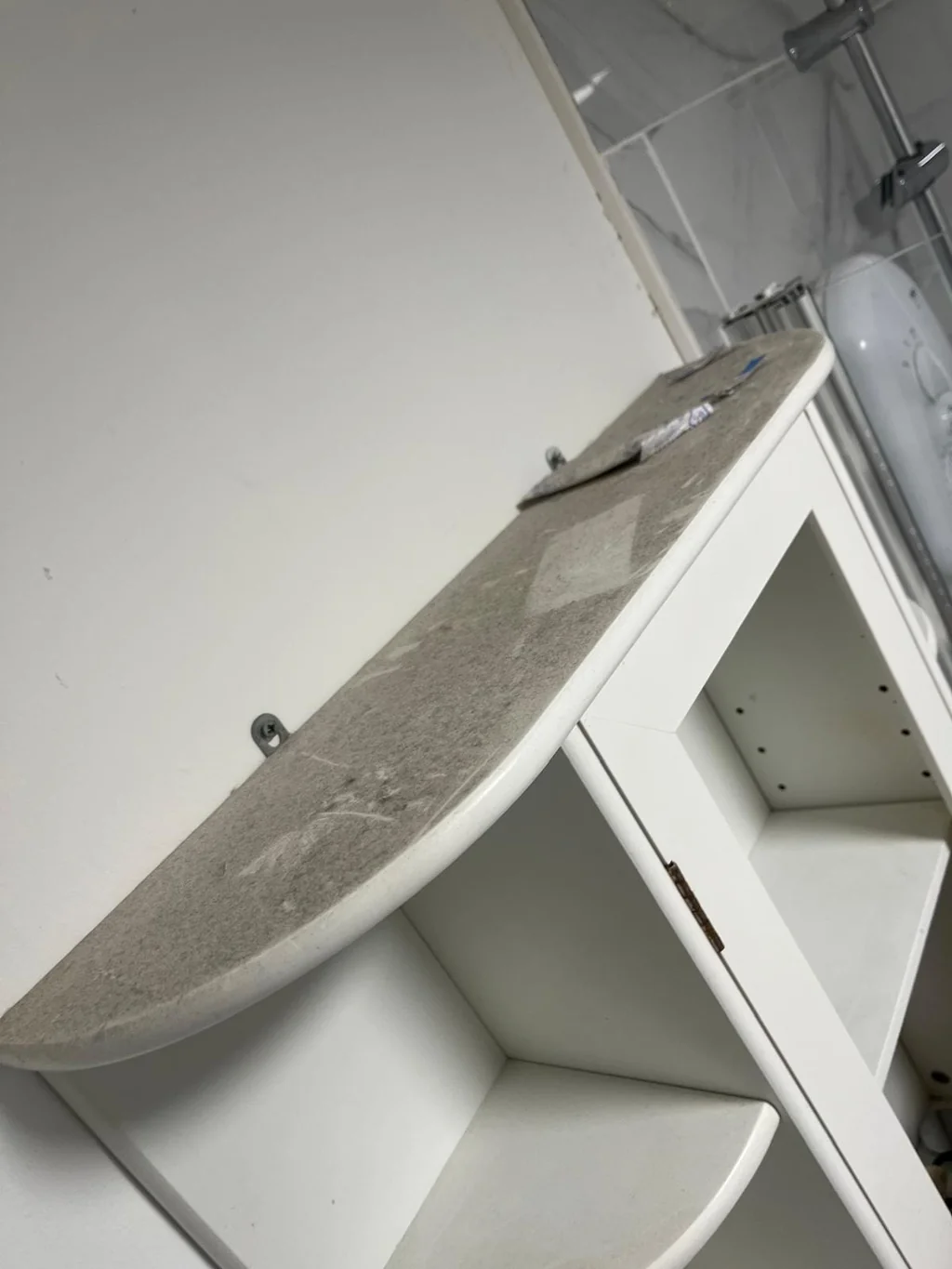 Bathroom shelf coated in thick dust before a thorough clean