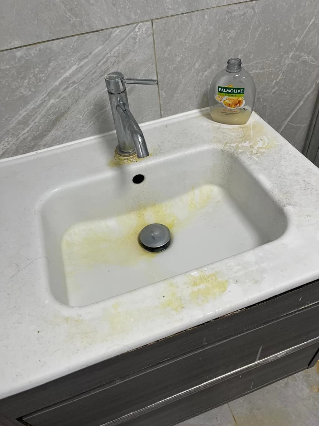 Vanity basin stained with limescale and grime before cleaning